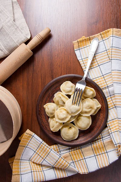 Geserveerd in klei plaat Oekraïense vlees knoedels of ravioli op hout — Stockfoto