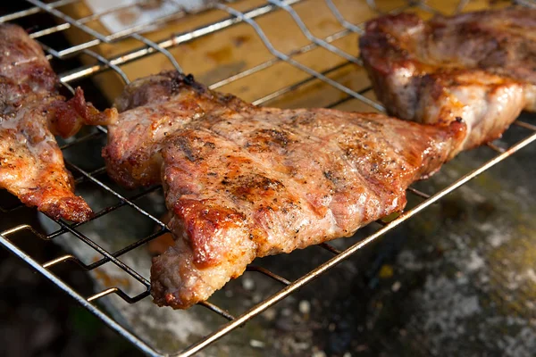 Vue rapprochée du steak de porc juteux cuit sur un gril à flamme nue . — Photo