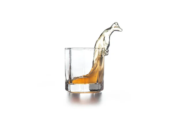 Salpicadura de whisky en vidrio con hielo sobre fondo claro — Foto de Stock
