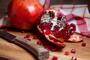 Ahşap zemin üzerinde antika bıçaklı taze kırmızı nar..