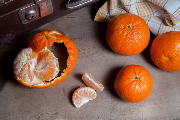 Unpeeled round ripe orange mandarins or tangerines and slices of