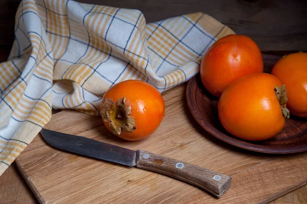 Whole ripe persimmon on a wooden background — Stock Photo, Image