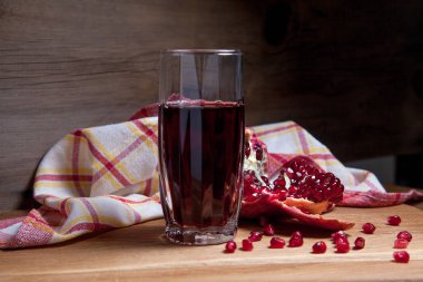 Taze kırmızı nar ve tahta üzerinde bir bardak taze Rudy suyu. 