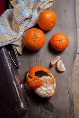 Soyulmamış yuvarlak portakal mandalinası veya mandalina ve dilimler