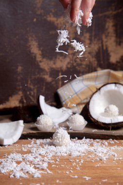 Çikolatalı hindistan cevizli mantar ve hindistan cevizli, beyaz hamurlu, hindistan cevizli. Beyaz çikolata, hindistan cevizi kabuğu, hindistan cevizi gevreği, kırılmış fındık, ahşap arka planda hindistan cevizi kırıntısı..