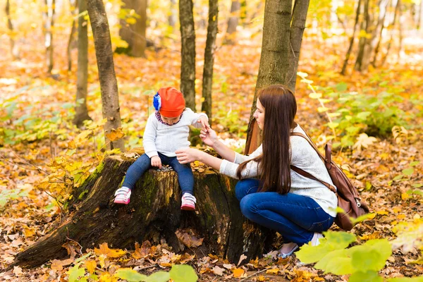 Joven madre con su pequeña niña en el parque de otoño —  Fotos de Stock