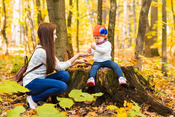 Мать и маленькая дочь играют вместе в осеннем парке — стоковое фото