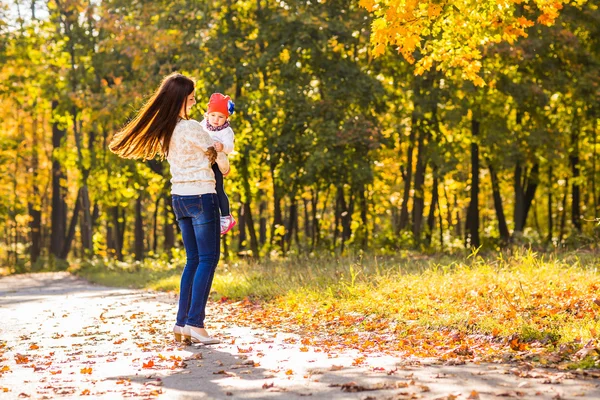 Moeder en kleine dochter samenspelen in herfst park — Stockfoto
