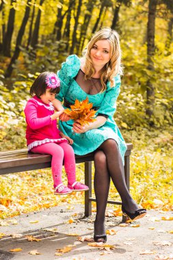 Anne ve kızı sonbahar parkında.