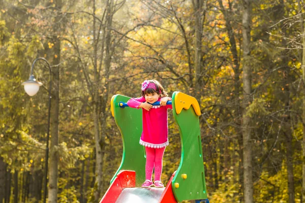 Niña divirtiéndose en el patio de recreo un día de otoño — Foto de Stock