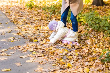 Anne ve kızı birlikte sonbahar parkta oynarken