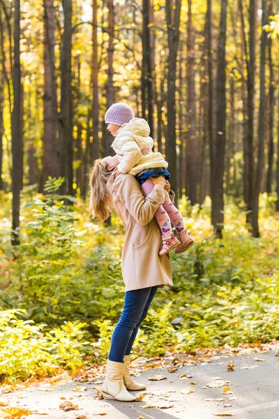 Niña y su madre jugando en el parque de otoño —  Fotos de Stock