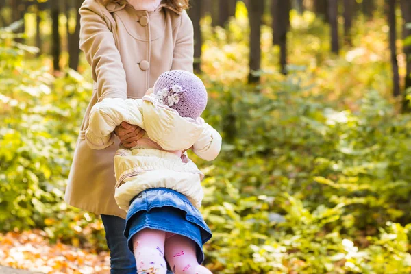 Dziewczynka i jej matka bawią się w jesiennym parku — Zdjęcie stockowe