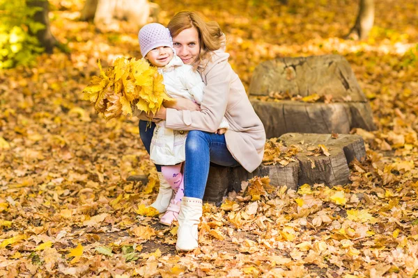 Rodina: matka a dítě malá dcera hrát, se smíchem, mazlení na podzimní procházku v přírodě přírodě — Stock fotografie