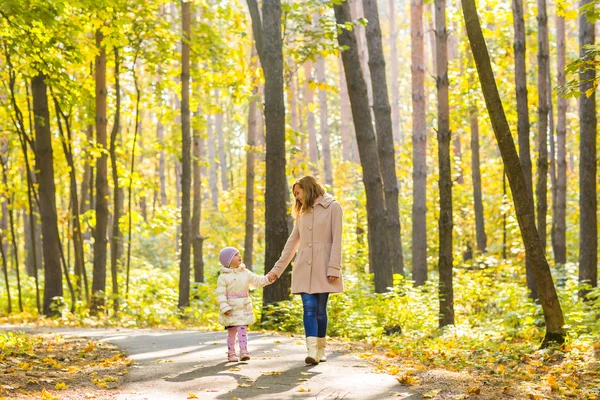 Anne ve çocuk sonbahar parkında yürüyor. — Stok fotoğraf
