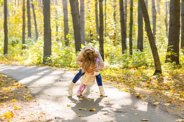 Madre e hija jugando juntas en el parque de otoño —  Fotos de Stock