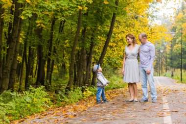 Genç aile bir sonbahar günü parkta yürüyüş