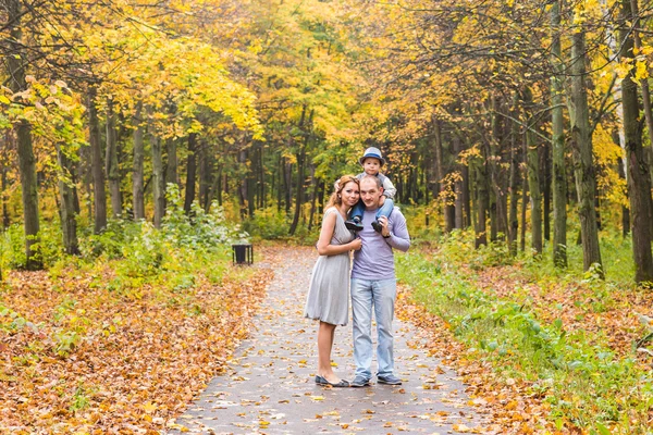 Famiglia felice giocando a cavalluccio nel parco autunnale — Foto Stock