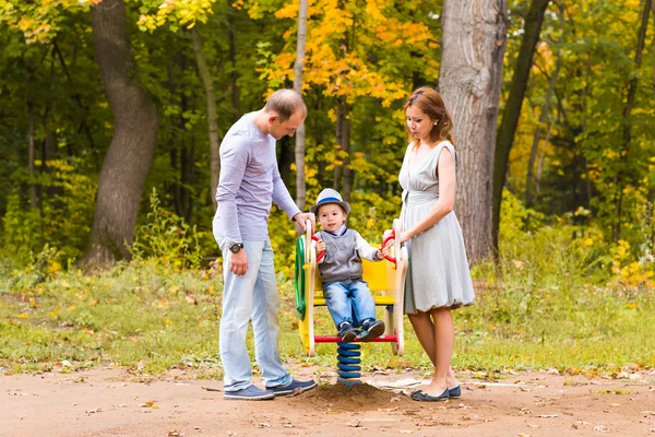 Niño juguetón con los padres en el patio al aire libre. Mamá, papá y niño . — Foto de Stock