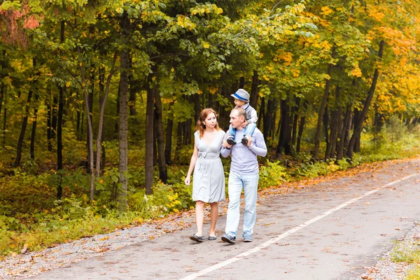 秋の日の公園を歩いて若い家族 — ストック写真