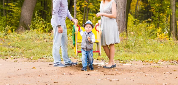 Lekfulla barn med föräldrar på lekplatsen utomhus. Mamma, Pappa och barn. — Stockfoto