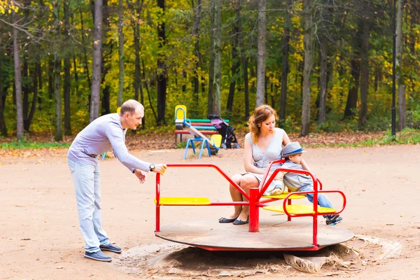 Niño juguetón con los padres en el patio al aire libre. Mamá, papá y niño . — Foto de Stock