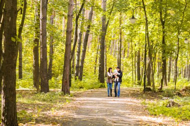 aşk, ebeveynlik, Aile, sezon ve insanlar kavramı - çift bebek sonbahar Park ile gülümseyen