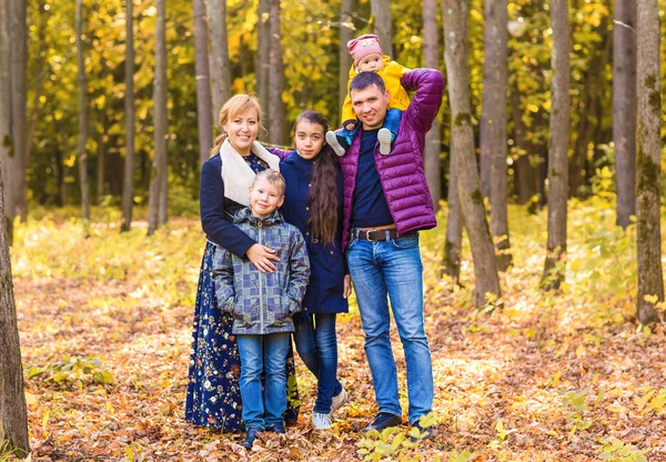 Família feliz se divertindo ao ar livre no parque de outono — Fotografia de Stock