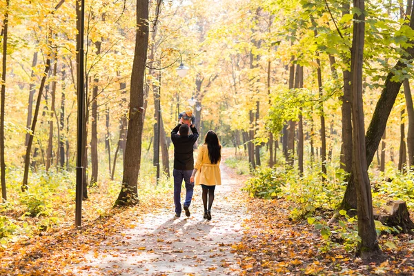 Felice giovane famiglia con la figlia trascorrere del tempo all'aperto nel parco autunnale — Foto Stock