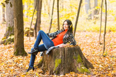 sonbahar park, güzel gülümseyen kadın ve sarı düşen yaprakları