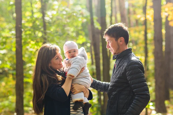 Amore, genitorialità, famiglia, stagione e concetto di persone - coppia sorridente con bambino nel parco autunnale — Foto Stock