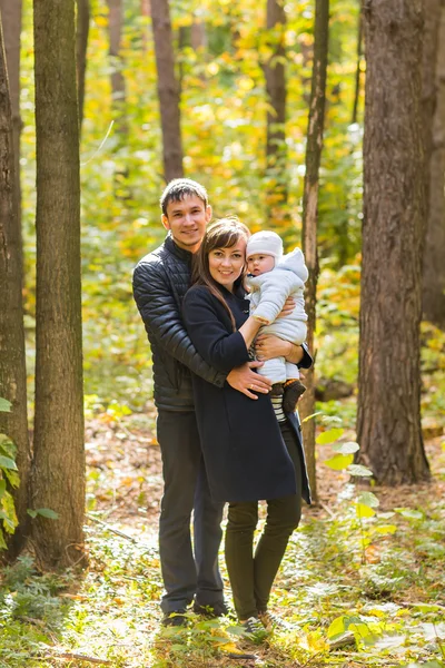秋の公園で赤ちゃんと一緒にカップルを笑顔 - 愛、親、家族、季節、人の概念 — ストック写真