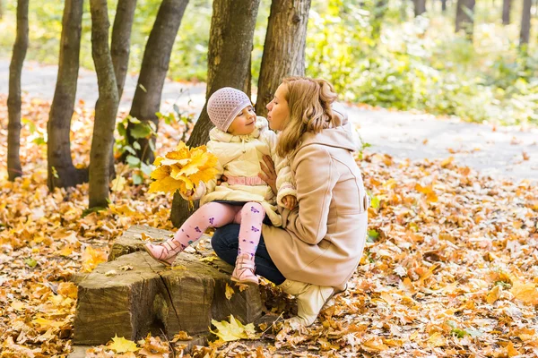 Ung mor och hennes småbarn flicka ha kul på hösten — Stockfoto