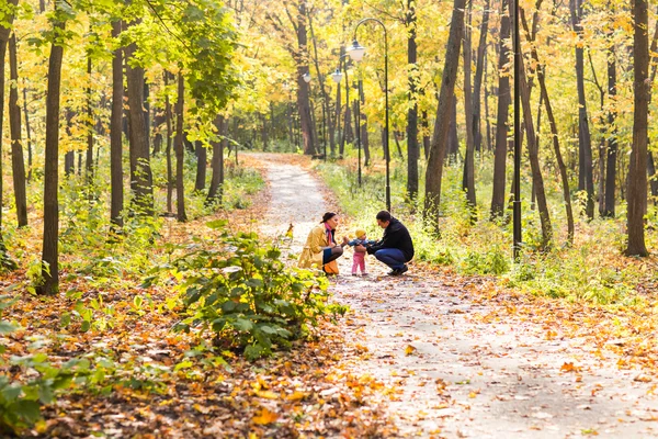 Счастливая семья играет в осеннем парке — стоковое фото