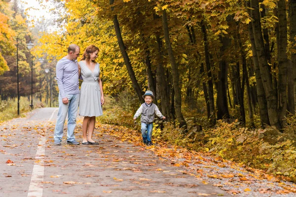 Happy young family walking down the road outside in green nature. — Stock Photo, Image
