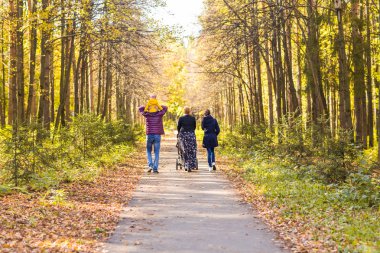 Genç aile açık havada sonbahar parkta yürüyüş
