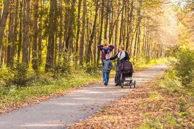 Genç aile açık havada sonbahar parkta yürüyüş