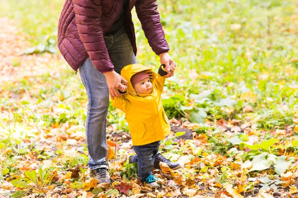Vater und sein kleiner Sohn amüsieren sich im Herbstpark — Stockfoto
