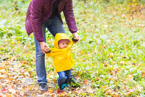 Padre y su pequeño hijo se divierten en el parque de otoño — Foto de Stock