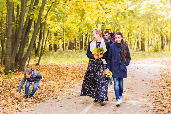 Mutlu genç aile birlikte dışarıda sonbahar doğada vakit. — Stok fotoğraf