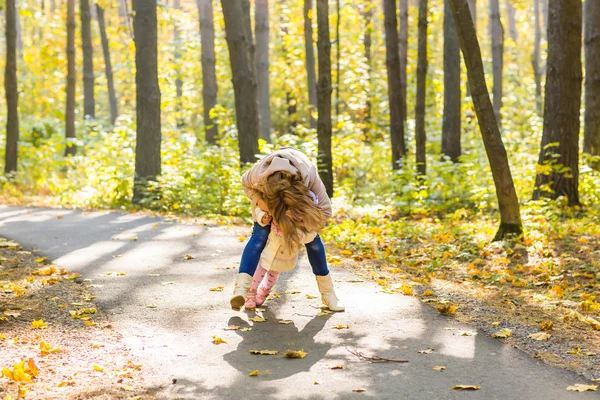 Щаслива родина мати і дитина сміються з листям в природі осінь — стокове фото
