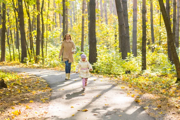 Ung mamma leker med sin dotter i höstparken — Stockfoto