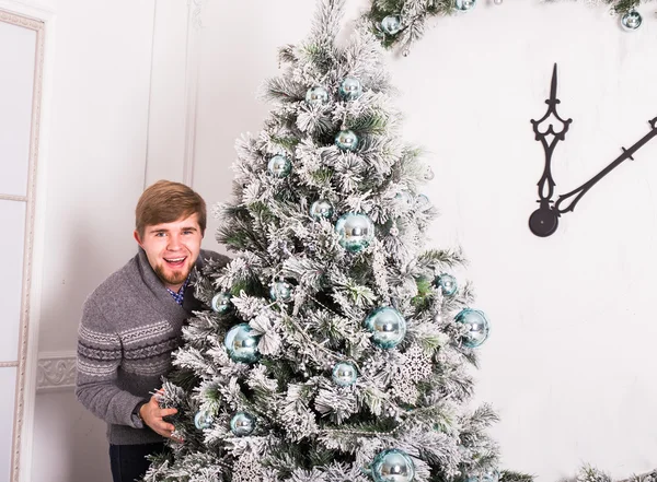 Gelukkig jongeman en kerstboom thuis — Stockfoto