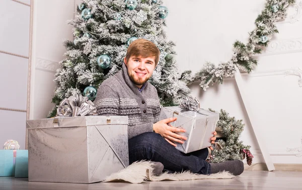 Kerstmis - gelukkig lachend Kaukasische man opent de doos van de gift — Stockfoto