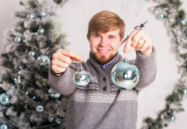 Periodo natalizio - giovane che tiene le palle di Natale — Foto Stock