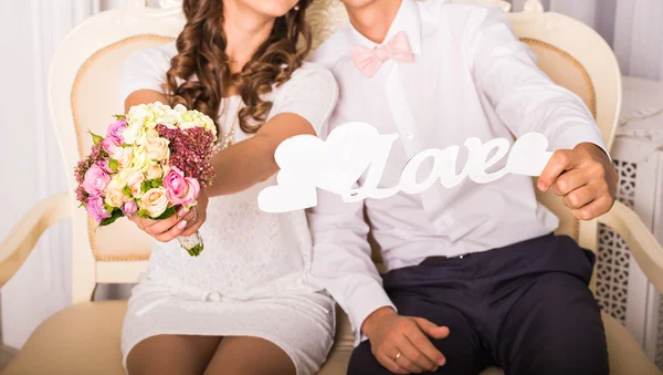 Casal segurando um sinal com a palavra amor — Fotografia de Stock