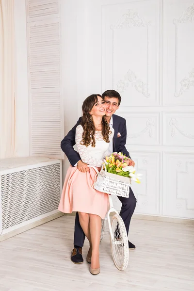 Modefoto von eleganten Liebespaar posiert im Studio mit klassischem Interieur in der Nähe des Fahrrads — Stockfoto