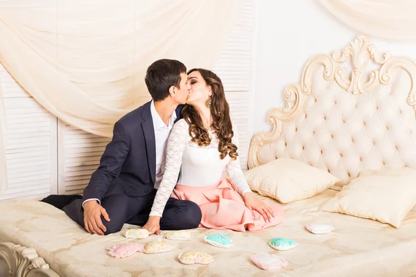 Happy elegant par kramas och kyssas på bakgrund av lyxiga interiörer. — Stockfoto
