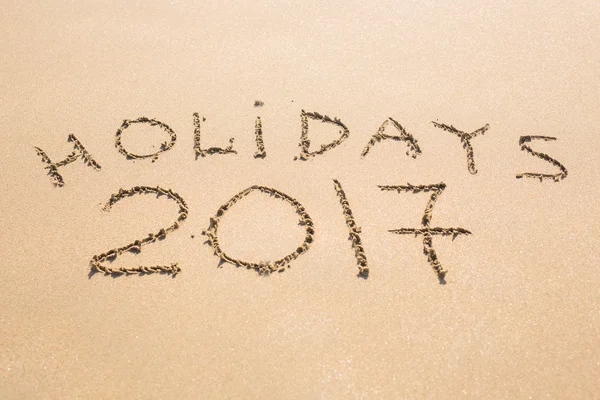 幸せな休日 2017。ビーチで砂に書かれました。休日は、クリスマス、新年 2017年コンセプト. — ストック写真