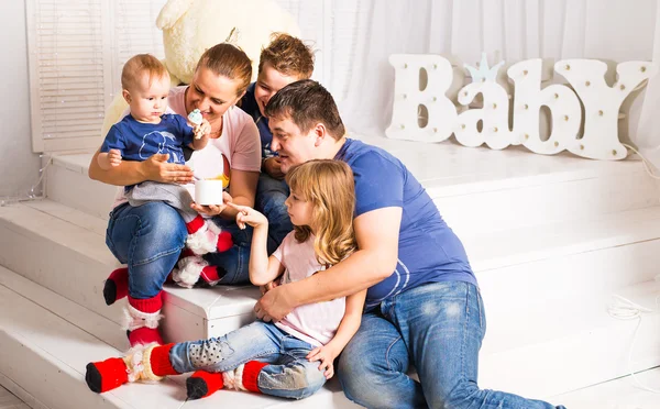 Família feliz com 3 crianças sentadas no chão da sala de estar em casa — Fotografia de Stock